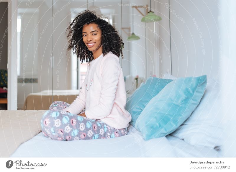 Happy beautiful young black woman relaxed sitting in the bed Woman Black Smiling Relaxation Beautiful awake Cute Bed Cozy Pyjama pajama Winter Cold Sit