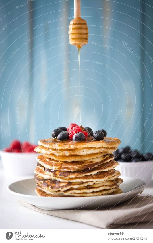 spoon honey pouring honey on pancake Pancake Blueberry Raspberry Dessert Sweet Breakfast Delicious Kitchen decor Plate Food Healthy Eating Food photograph Meal