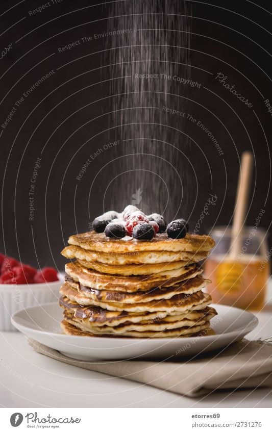 Woman pouring sugar in pancakes Pancake Blueberry Raspberry Dessert Sweet Breakfast Delicious Kitchen Decoration Plate Food Food photograph Meal Fruit Group