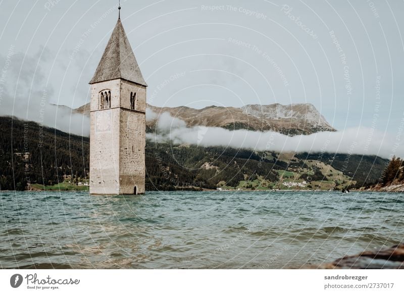 Church in water - Reschensee Resia Water Lake Reschen reschenpass Alps South tyrolian south Tyrol Clouds mountains Church spire bells Drown Belief