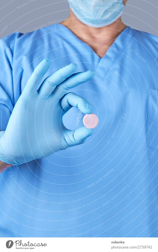 doctor in blue latex gloves holding a large round pill Health care Medical treatment Illness Medication Doctor Hospital Human being Hand Gloves Stand Blue White