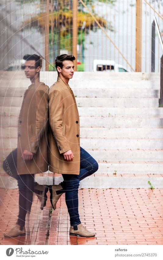 Side view of young trendy man leaning on black wall Lifestyle Elegant Style Beautiful Hair and hairstyles Human being Masculine Young man Youth (Young adults)