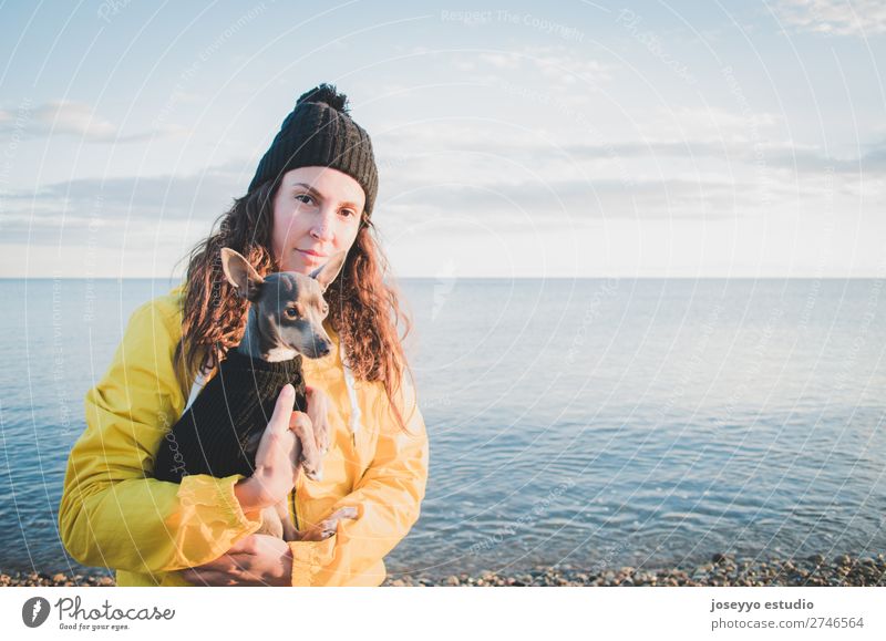 Woman with her little dog on the beach Lifestyle Relaxation Trip Freedom Sun Beach Winter Friendship 30 - 45 years Adults Nature Animal Horizon Coast Jacket