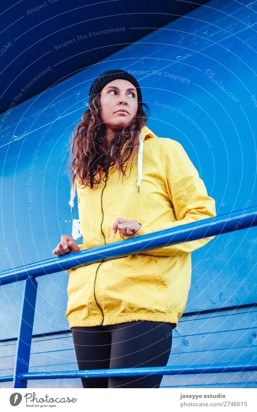 Young woman on a lifeguard tower Lifestyle Relaxation Trip Freedom Sun Beach Winter Sports Meeting 30 - 45 years Adults Nature Coast Fashion Jacket Hat Yellow