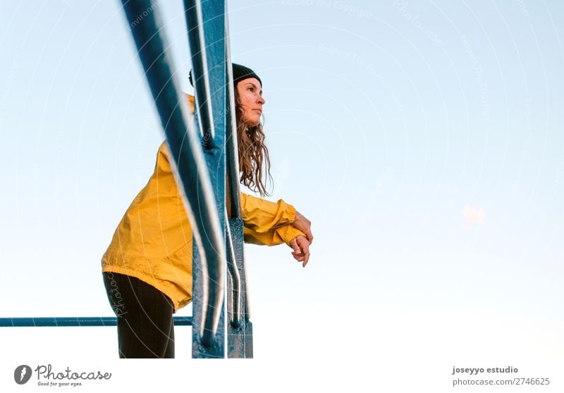 Brunette woman on a lifeguard tower Lifestyle Relaxation Trip Freedom Sun Beach Ocean Winter Sports Meeting 30 - 45 years Adults Nature Horizon Coast Fashion