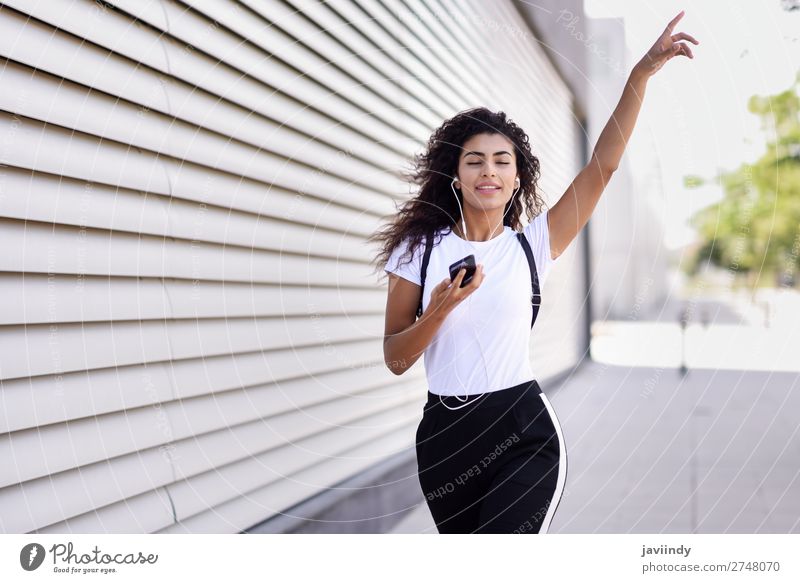 African woman listening to music with earphones and smartphone Style Joy Happy Beautiful Hair and hairstyles Music Sports Telephone PDA Technology Human being