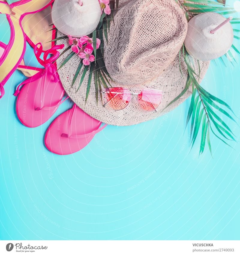 Summer background . Top view of woman's summer beach accessories: bikini,  flip flops, sunglasses, straw hat, palm leaves and tropical flowers on turquoise blue background, banner with copy space