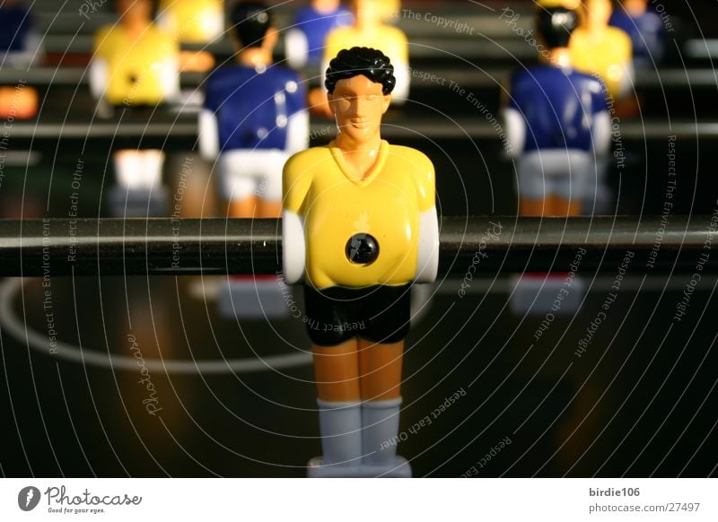 Whole guys 01 Table soccer Playing Toys Leisure and hobbies Front view Yellow Blue Rod Shallow depth of field Close-up Colour photo Piece