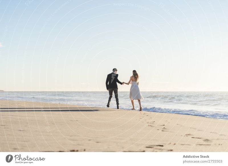 Romantic bride and groom strolling on beach Couple Bride Groom To go for a walk in love Beach romantic Relationship holding hands Dream Youth (Young adults)