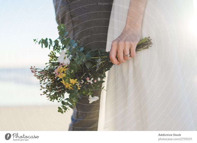 Crop bride with bouquet embracing groom Couple bridal Embrace Bouquet Feasts & Celebrations Wedding Nature romantic Beach Traveling Love Rustic Flower Together