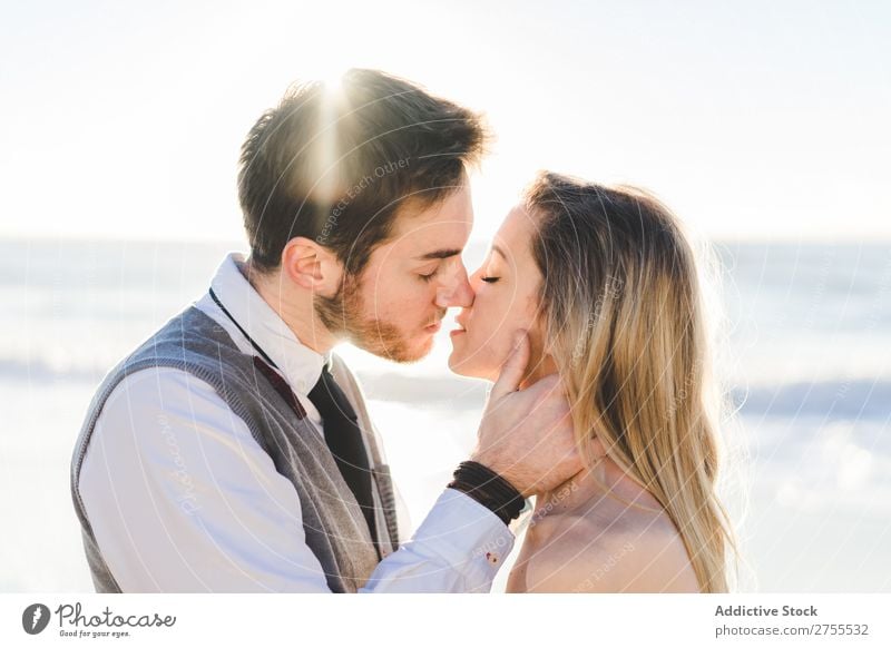 Tender kissing bridal couple in sunlight Couple Wedding Beach Sunlight embracing Engagement Contentment valentine enjoyment in love seascape Stand Relationship