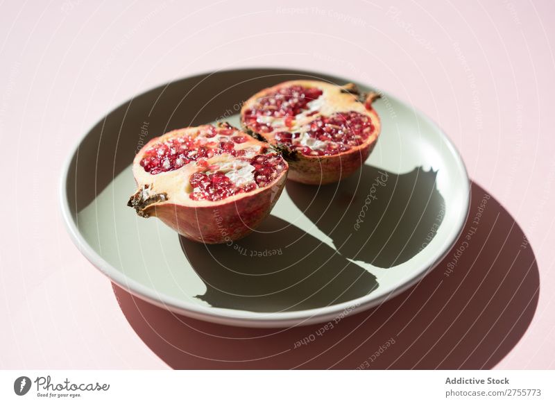 Halves of pomegranate in sunlight Pomegranate halves minimalist Mature Red Fruit Sweet Creativity Juicy section Organic Plate Shadow Multicoloured Arrangement