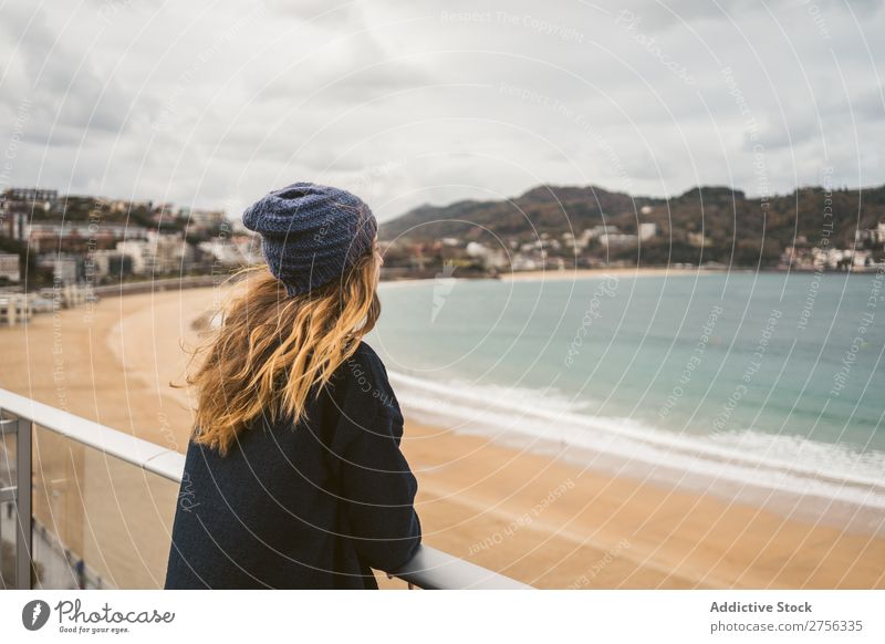 Woman at handrail at seaside Youth (Young adults) Coast Ocean Looking away Stand Lean Handrail pretty Attractive Hat Nature Water Vacation & Travel Beach