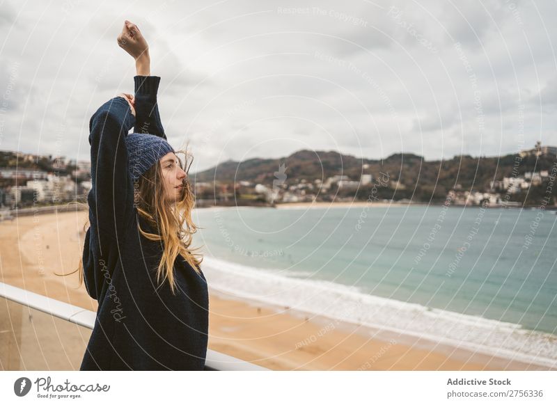 Woman at handrail at seaside Youth (Young adults) Coast Ocean Looking away Stand Lean Handrail pretty Attractive Hat Nature Water Vacation & Travel Beach