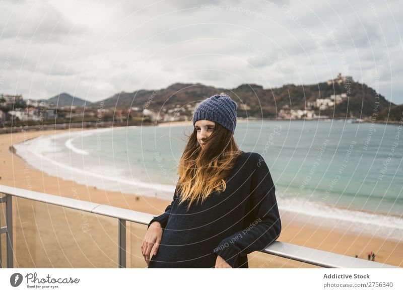 Woman at handrail at seaside Youth (Young adults) Coast Ocean Looking away Stand Lean Handrail pretty Attractive Hat Nature Water Vacation & Travel Beach