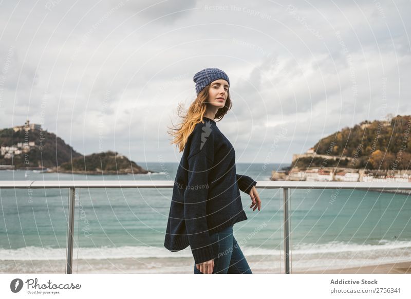 Woman at handrail at seaside Youth (Young adults) Coast Ocean Looking away Stand Lean Handrail pretty Attractive Hat Nature Water Vacation & Travel Beach