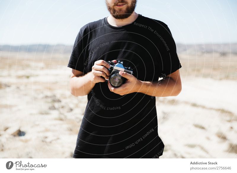 Crop man with camera on desert Man Hand Camera Illusion Trick Desert Vacation & Travel Lifestyle Human being Adults Nature Adventure Trip Hot Flying Tourist