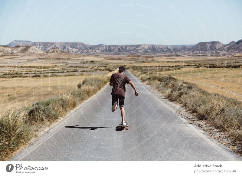 Man riding skateboard on prairie road Skateboard Street Vacation & Travel Lifestyle Human being Adults Nature Adventure Trip Tourist Landscape