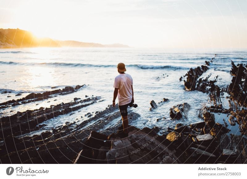 Man with camera on coastal rock Tourist Cliff Ocean Rock shots Camera Photographer Vacation & Travel Tourism Nature Landscape Coast Water Sun Freedom Stone