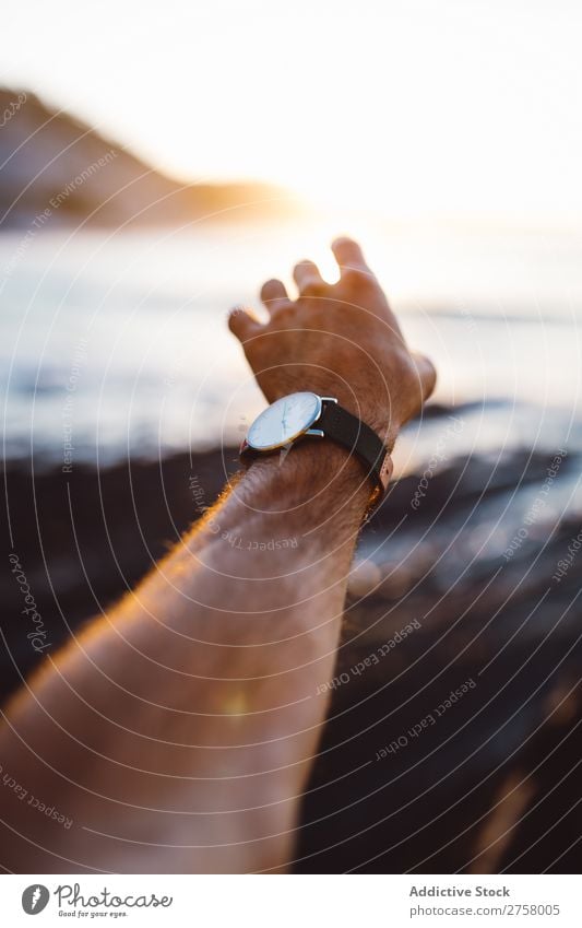 Crop extended man at seaside Human being Man Hand Ocean Landscape Water Coast Vacation & Travel Nature Summer Sky Rock Island Tourism Sunlight Sunset Beautiful