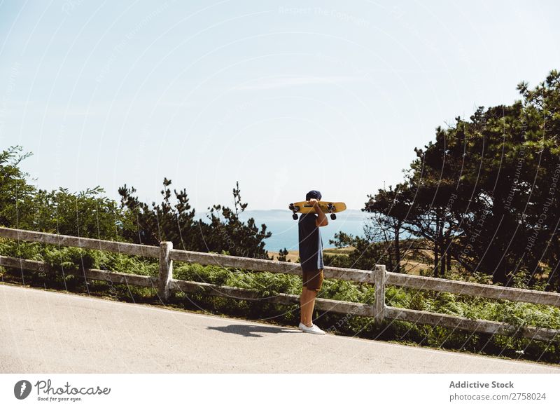 Man holding skateboard near fence skateboarder riding Asphalt seaside Sports Skateboard Lifestyle Ice-skating Skateboarding Ice-skates Extreme Sunbeam Board