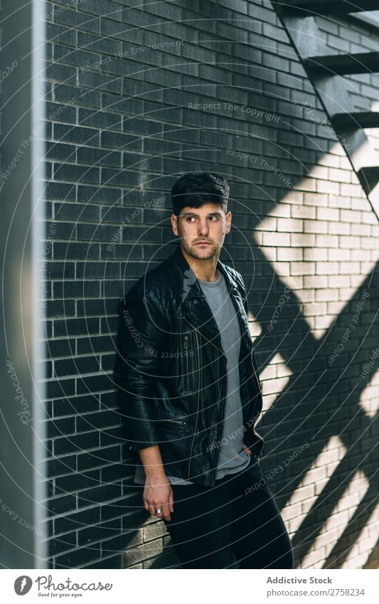 Young pensive man near fire stairs stylish thoughtful looking at camera sitting confident young cool person portrait modern model fashionable male serious