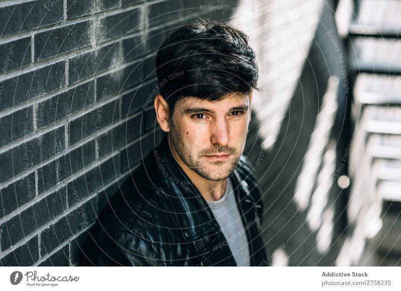 Young pensive man near fire stairs stylish thoughtful looking at camera sitting confident young cool person portrait modern model fashionable male serious