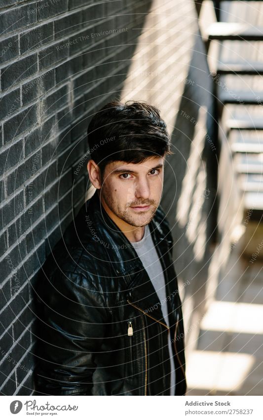 Young pensive man near fire stairs stylish thoughtful looking at camera sitting confident young cool person portrait modern model fashionable male serious