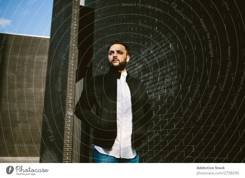 Thinking man at the brick wall looking away thoughtful pensive stylish standing confident young cool person portrait modern model fashionable male serious