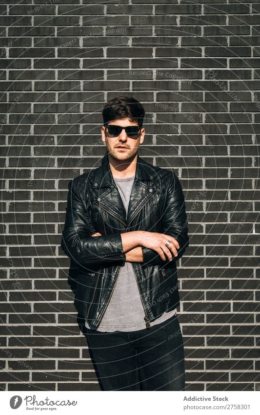 Young man over a brick wall stylish pensive thoughtful looking at camera sitting stairs confident young cool person portrait modern model fashionable male