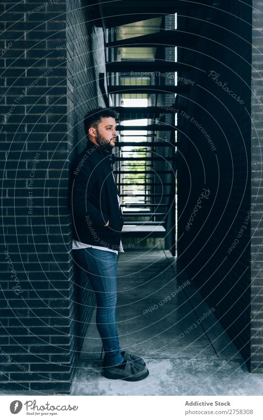 Cool young man wearing leather jacket posing near fire stairs. step confident cool person portrait modern model fashionable male serious cheerful smiling casual