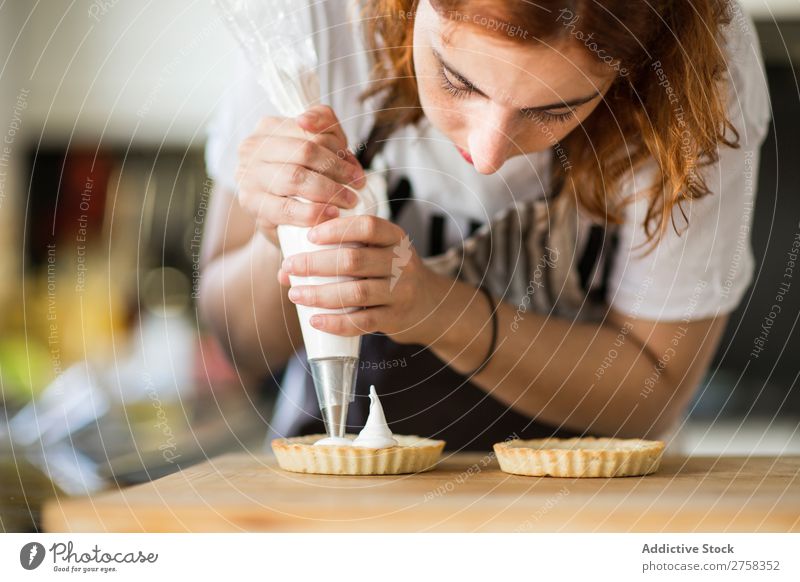 Woman putting cream on tarts Dessert Cooking Cream pastry bag meringue Kitchen Food Sweet recipe Baked goods Home Preparation Baking Human being Make chef Dough