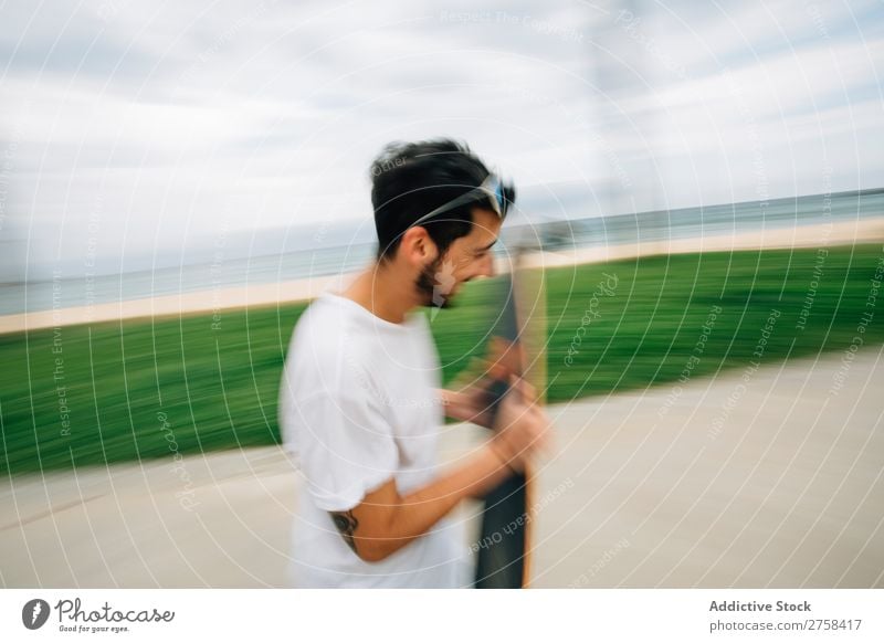 Man in summer outfit skating on road near sea. Joy Running Blur Exterior shot Action Ride Athletic Ice-skates skaters handsome Youth (Young adults)