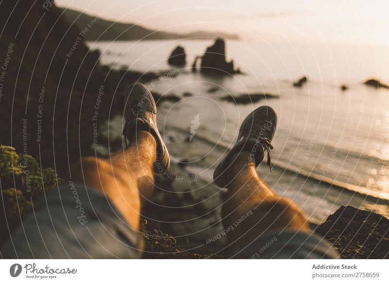 Legs of man sitting at cliff Human being Hill Mountain Nature Sit Edge seaside Evening Sunset Landscape Vacation & Travel Beautiful Vantage point Summer Tourism