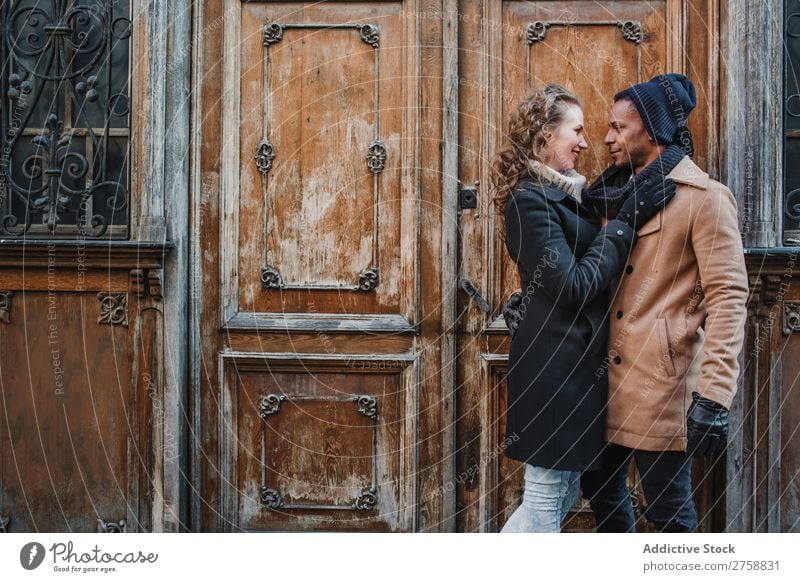 Couple embraced at vintage door multiethnic Style Street warm clothes Wood Door grungy Old Easygoing Beautiful Mixed race ethnicity Black Youth (Young adults)