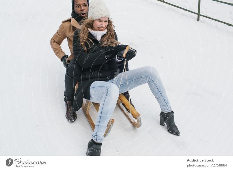 Couple riding sledge on snowy hill multiethnic Style warm clothes Easygoing Nature Sledge Winter Snow Beautiful Mixed race ethnicity Black Youth (Young adults)