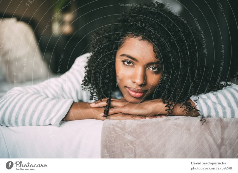 close up of a pretty black woman with curly hair smiling and lying on bed looking at the camera Woman Bed Portrait photograph Close-up Lie (Untruth) Black