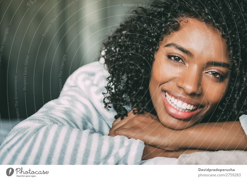 close up of a pretty black woman with curly hair smiling and lying on bed looking at the camera Woman Bed Portrait photograph Close-up Lie (Untruth) Black