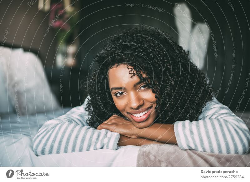 close up of a pretty black woman with curly hair smiling and lying on bed looking at the camera Woman Bed Portrait photograph Close-up Lie (Untruth) Black