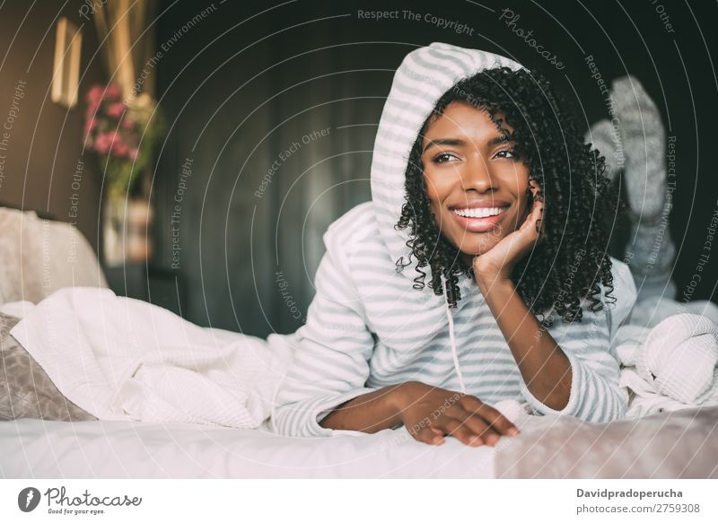 close up of a pretty black woman with curly hair smiling and lying on bed looking away Woman Bed Portrait photograph Close-up Lie (Untruth) Black Smiling