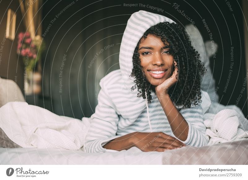 close up of a pretty black woman with curly hair smiling and lying on bed looking at the camera Woman Bed Portrait photograph Close-up Lie (Untruth) Black