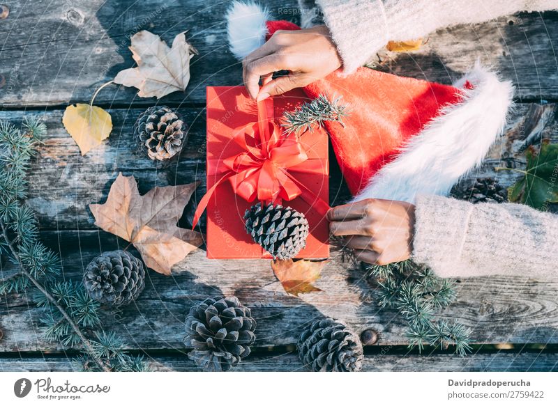 Woman arms doing christmas decoration in a wood table outdoors Christmas & Advent Gift Hat Santa Claus Life Still Life Hand Arm Background picture Decoration