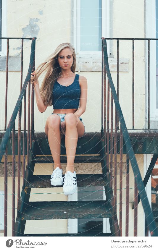 Young fit beautiful blonde woman sitting on the stairs posing Woman Portrait photograph Smiling Youth (Young adults) Considerate pretty Athletic Stairs Sit Blue