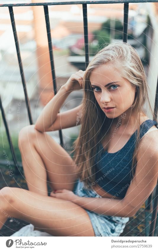 Young fit beautiful blonde woman sitting on the stairs posing Woman Portrait photograph Smiling Youth (Young adults) Considerate pretty Athletic Stairs Sit Blue