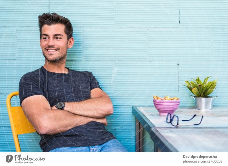 Happy young man seating in a restaurant Adults Loneliness Attractive Beautiful Blue Bright Caucasian Coffee Café Multicoloured enjoying Food Fries Guy handsome