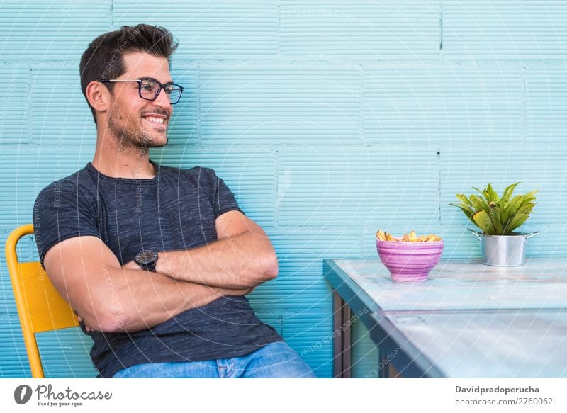 Happy young man seating in a restaurant Adults Loneliness Attractive Beautiful Blue Bright Caucasian Coffee Café Multicoloured enjoying Food Fries Guy handsome