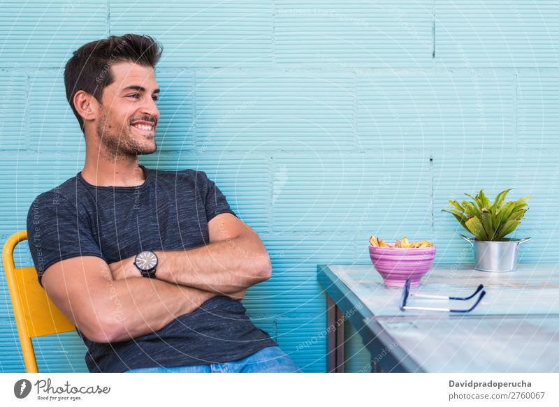 Happy young man seating in a restaurant Adults Loneliness Attractive Beautiful Blue Bright Caucasian Coffee Café Multicoloured enjoying Food Fries Guy handsome