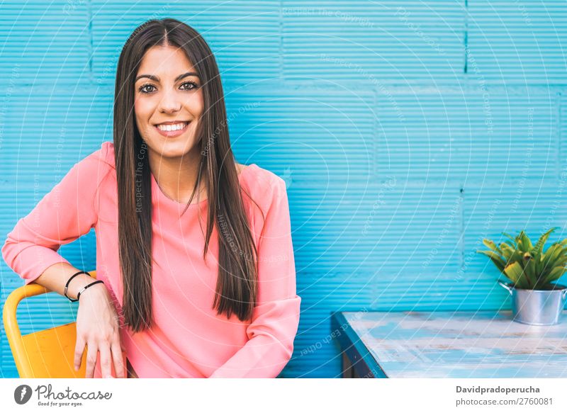 Happy young woman seating in a restaurant Adults Loneliness Attractive Beautiful Blue Bright brunet Caucasian Coffee Café Multicoloured enjoying Woman Food Girl