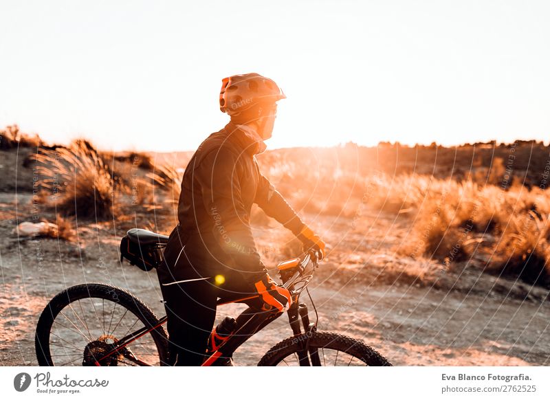 Cyclist Riding a Bike at dunset. Sports Lifestyle Relaxation Leisure and hobbies Adventure Summer Sun Mountain Cycling Bicycle Masculine Young man