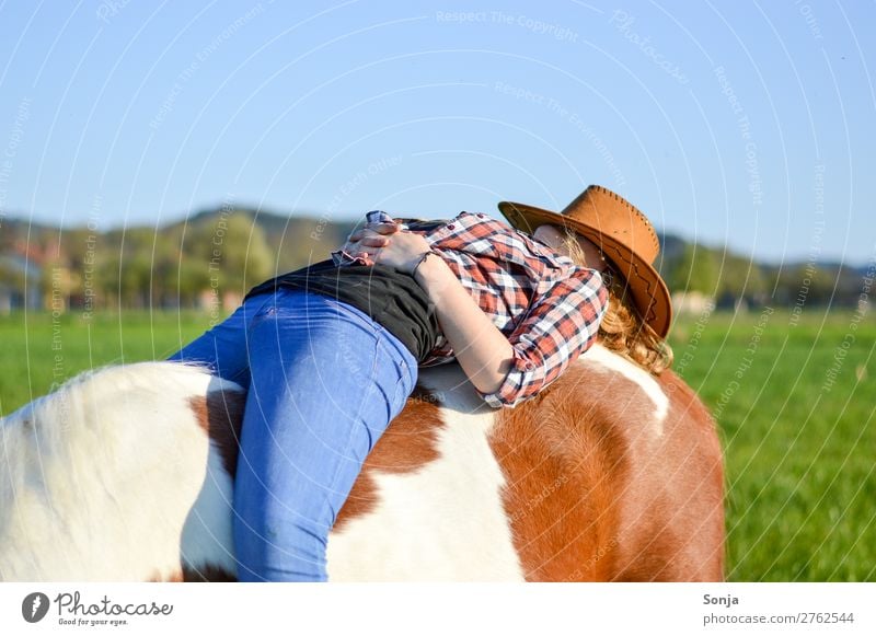 Young woman sleeping on a horse Lifestyle Ride Trip Summer Feminine Youth (Young adults) 1 Human being 18 - 30 years Adults Shirt Jeans Hat Animal Horse Sunhat